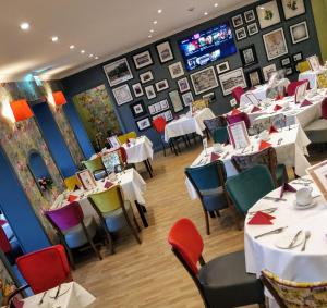 a dining room with tables and chairs and pictures on the walls at The Lodge Hotel in Coleraine