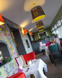 un ristorante con tavoli, sedie e un camino di The Lodge Hotel a Coleraine