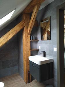 La salle de bains est pourvue d'un lavabo blanc et de plafonds en bois. dans l'établissement B&B Landhof Schober, à Weißbriach