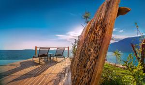 two chairs sitting on a wooden deck next to the water at Mandalina Suites in Kaş