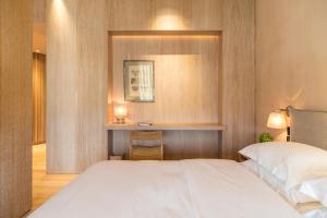 a bedroom with a white bed and a desk at The Margi in Athens