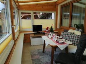 a screened in porch with a table and a television at Ferienwohnungen Rupertihaus in Flachau