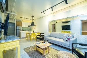 ein Wohnzimmer mit einem Sofa und einem Tisch in der Unterkunft Baycliff Residence by Lofty in Patong Beach