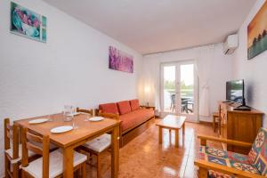 a living room with a table and a couch at Playa Parc Apartments in Son Parc