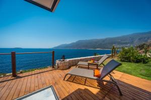 a patio with a table and a chair on a deck at Mandalina Suites in Kaş