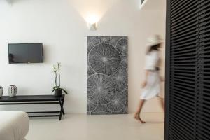 a woman walks through a bedroom with a wall mural at Nimbus Mykonos in Agios Stefanos