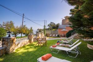 a patio with a table and chairs on the grass at Anna Apartments Boukari in Boukari