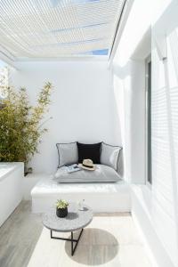 a small patio with a couch and a table at Nimbus Mykonos in Agios Stefanos