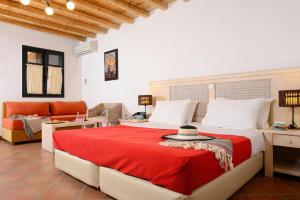 a bedroom with a large bed with a red blanket at The Varos Residences Hotel in Város