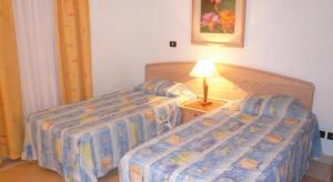 シャルム・エル・シェイクにあるLogaina Sharm Resort Apartmentsのベッド2台(テーブル上のランプ付)が備わるベッドルーム1室