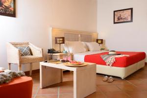 a bedroom with a bed and a table and a chair at The Varos Residences Hotel in Város