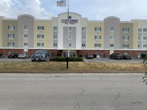 a large building with a car parked in a parking lot at Candlewood Suites Jonesboro, an IHG Hotel in Jonesboro