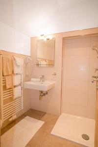 a bathroom with a sink and a shower with a mirror at Haus Hamatli in Sankt Anton am Arlberg