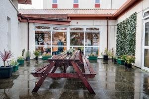 a picnic table in the rain in front of a store at Inverness Youth Hostel in Inverness