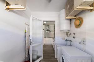 a white bathroom with a washer and dryer in it at Apartment Gual 1 By SunVillas Mallorca in Port de Pollensa