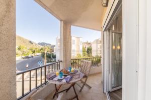 een balkon met een tafel en stoelen en uitzicht op een straat bij Apartment Gual 1 By SunVillas Mallorca in Port de Pollença