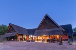 a large building with a gambrel roof at Hobatere lodge in Otjovasandu