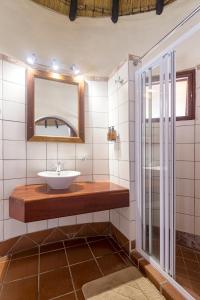 a bathroom with a sink and a mirror at Hobatere lodge in Otjovasandu