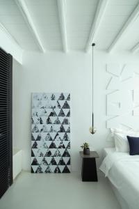 a bedroom with white walls and a wall mural of bats at Nimbus Mykonos in Agios Stefanos