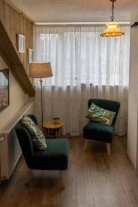a living room with two chairs and a lamp at B&B Aan het Park Eindhoven in Eindhoven