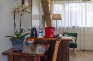 a wooden table with a vase of flowers on it at B&B Aan het Park Eindhoven in Eindhoven