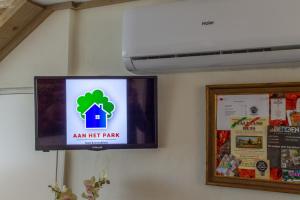 a tv hanging on a wall with a am net plan sign at B&B Aan het Park Eindhoven in Eindhoven