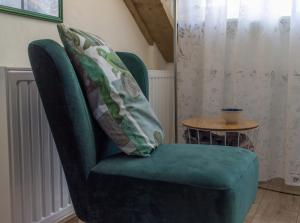 a green chair with two pillows on top of it at B&B Aan het Park Eindhoven in Eindhoven