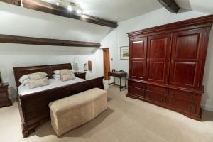 a bedroom with a large bed with wooden cabinets at West Arms Hotel in Llanarmon Dyffryn-Ceiriog