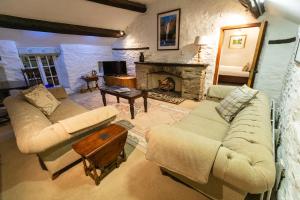 a living room with two couches and a fireplace at West Arms Hotel in Llanarmon Dyffryn-Ceiriog
