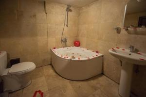 La salle de bains est pourvue d'une baignoire, de toilettes et d'un lavabo. dans l'établissement Karamanli Konagi, à Guzelyurt