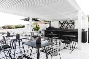 a group of tables and chairs on a patio at Nimbus Mykonos in Agios Stefanos