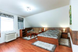 a bedroom with a bed and a desk and a window at GÁRDI APARTMAN in Szekszárd