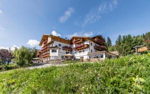 un gran edificio con una montaña en el fondo en Hotel Kompatscherhof, en Luson