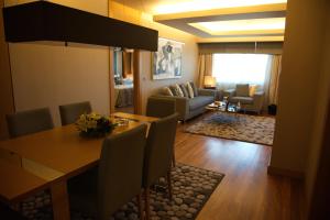 CPAnkara Hotel في أنقرة: غرفة مع طاولة طعام وغرفة معيشة