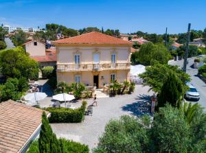a large yellow house with a balcony on a street at Hôtel Du Soleil in Saint-Raphaël