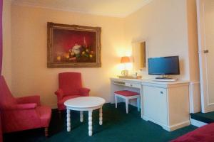 a room with a desk with a computer and two chairs at ARTEMIS SUITE in Barbizon