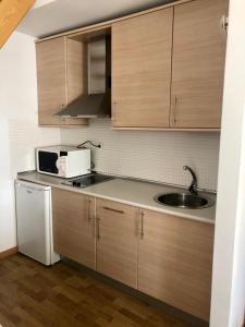 Una cocina con gabinetes de madera y un fregadero. en GLP Sierra nevada, en Sierra Nevada 1 foto más