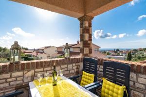 un patio con mesa y sillas en una pared de ladrillo en Villa-Johanna, en Kaštelir