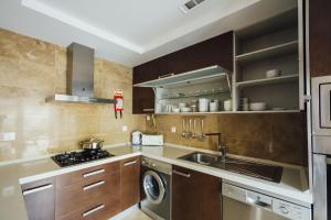 a kitchen with a stove and a sink and a washer at Baia Residence 2 - Holiday Apartments - By SCH in São Martinho do Porto