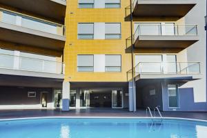 an empty swimming pool in front of a building at Baia Residence 3 - Holiday Apartments - By SCH in São Martinho do Porto