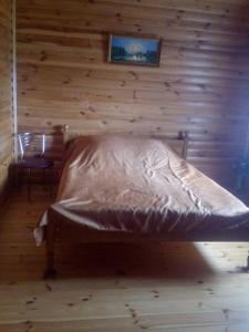 a bed in a room with a wooden wall at Эко отель и баня in Kosharishche