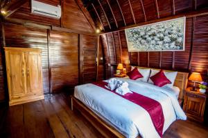 a bedroom with a large bed with wooden walls at Sekar Ayu Spa Salon & Bungalow in Nusa Penida