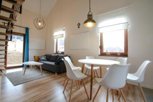 a living room with a table and white chairs at domki Stara Morawa in Stronie Śląskie