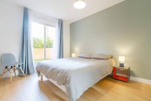 een slaapkamer met een groot bed en een groot raam bij 2 chambres Terrasse Parking Toulouse Centre Gare in Toulouse