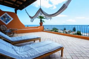 Un balcón con camas y vistas al océano. en Hotel Mamma Santina en Santa Marina Salina