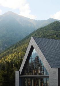 
a large building with a view of the mountains at Lefay Resort & SPA Dolomiti in Pinzolo
