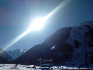 Słońce świeci nad śnieżną górą w obiekcie Affittacamere Chez Magan w mieście Gignod
