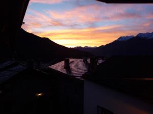 a sunset in the mountains with a view of a house at Affittacamere Chez Magan in Gignod