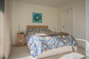 a bedroom with a bed with a colorful comforter at Sea Loch View Holiday Home in Portree