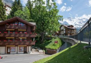 a building on a hill with mountains in the background at Chalet Waldschluecht in Wengen